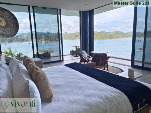 a bedroom with a large bed with a view of the water at Vivanti Resort in Guatapé
