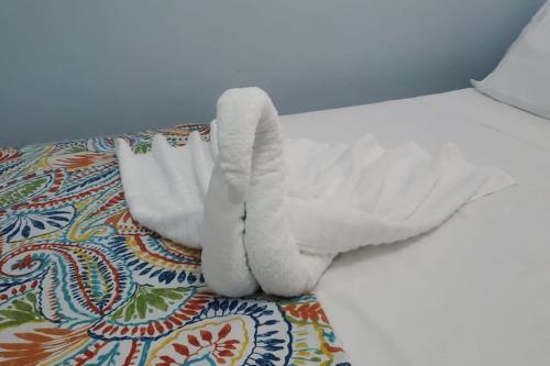 un letto con lenzuola e cuscini bianchi sul pavimento di 28 Steber a Roseau