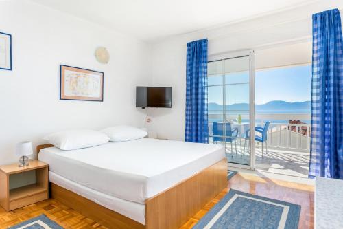 a bedroom with a bed and a balcony at Studio Podaca 6736b in Podaca