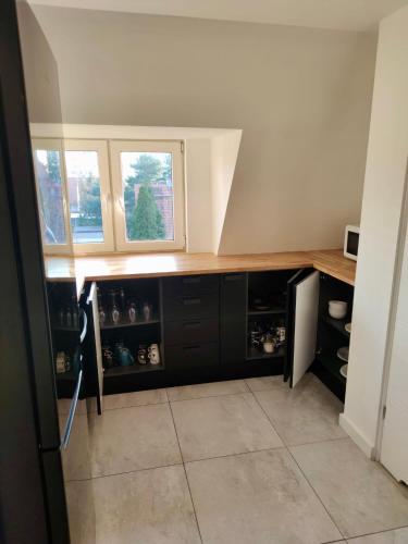 a kitchen with a counter and two windows in it at Apartament Michałowskiego w pobliżu Radiostacji in Gliwice