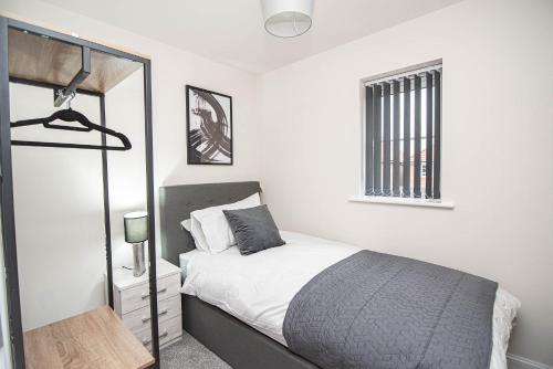 a white bedroom with a bed and a mirror at Solid Mirror Modern Riverside Home, Doncaster in Doncaster