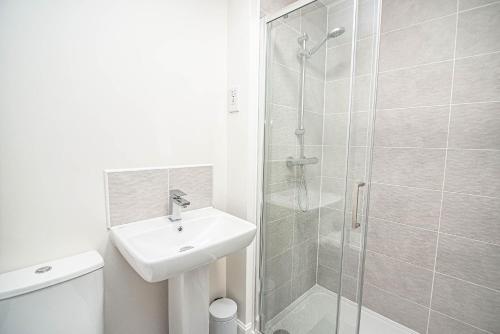 ドンカスターにあるSolid Mirror Modern Riverside Home, Doncasterの白いバスルーム(シンク、シャワー付)