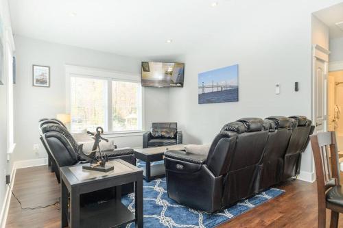 a living room with black leather chairs and a table at BayRidge house by Quiet Waters, Thomas Point Parks in Annapolis