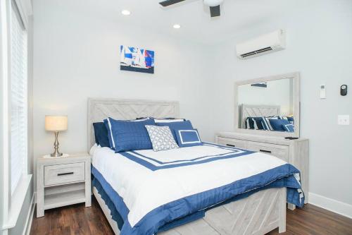 een slaapkamer met een bed met blauwe kussens en een spiegel bij BayRidge house by Quiet Waters, Thomas Point Parks in Annapolis