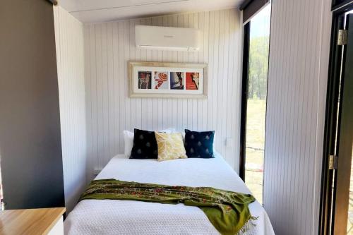 a bedroom with a bed and a window at Tiny Retreat Noosa in Cooroibah