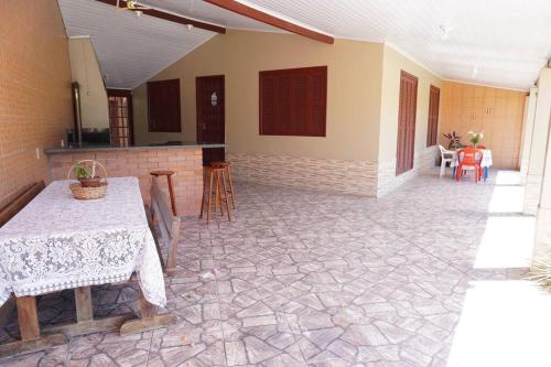 ein Wohnzimmer mit einem Tisch und Stühlen in einem Haus in der Unterkunft Casa aconchegante in Passo de Torres