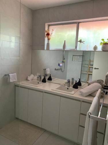 een badkamer met 2 wastafels en een spiegel bij Balcombe Retreat in Mount Martha