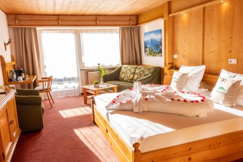 ein Schlafzimmer mit einem Bett und einem Sofa in der Unterkunft Gasthaus-Pension Seeklause in Ramsau bei Berchtesgaden