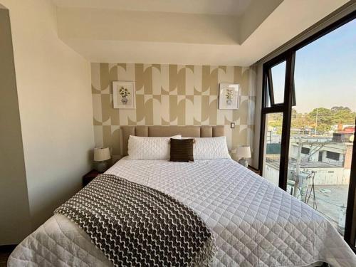 sypialnia z łóżkiem i dużym oknem w obiekcie Minimalist 3 Bedroom Apartment w mieście Gwatemala