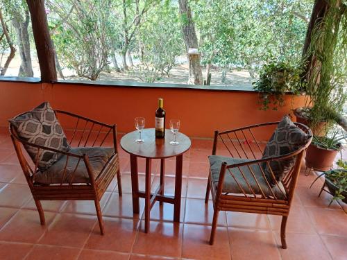 a table with two chairs and a bottle of wine at Casa Amapola in La Cruz