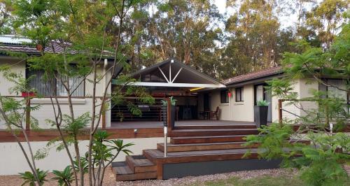 a home with a porch and stairs to a house at Marbles on Lovedale in Lovedale