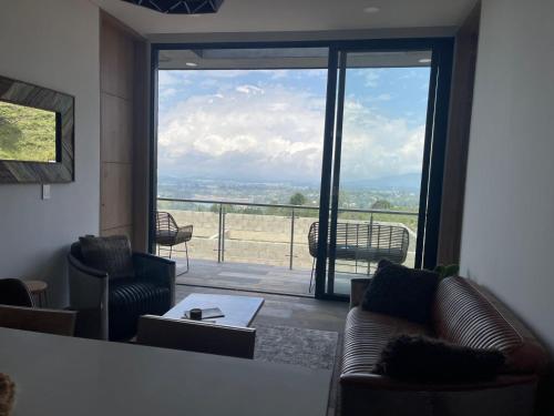 a living room with couches and a large window at Montecielo Hosting in Guatapé