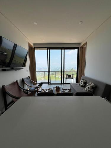 a living room with a couch and a large window at Montecielo Hosting in Guatapé