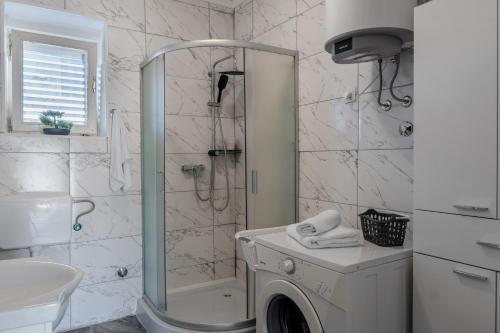 y baño con ducha y lavadora. en Apartments with parking space Vir - 22682, en Vir