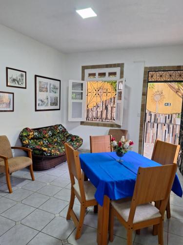 uma sala de jantar com uma mesa azul e cadeiras em Casa com ar condicionado em Lauro de Freitas