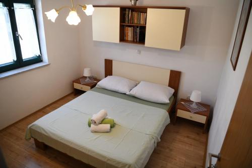 a bedroom with a bed with two stuffed animals on it at Apartments by the sea Bosana, Pag - 22692 in Pag