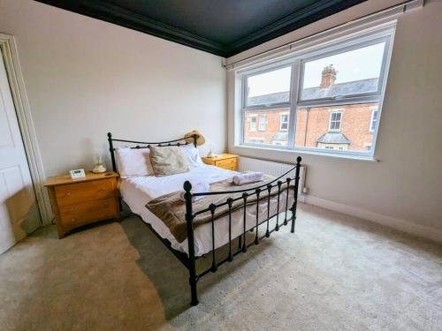 a bedroom with a bed and a large window at Beautiful 2 BR home close to the city in Morpeth