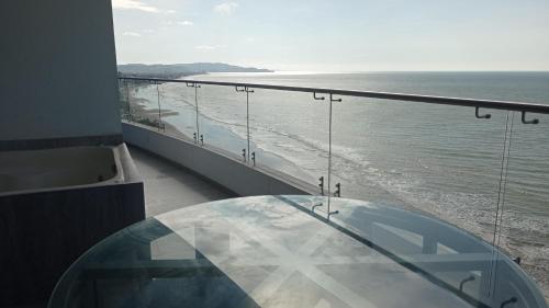 a glass table on a balcony overlooking the ocean at Grand Diamond Beach Tonsupa in Tonsupa