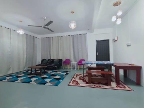 een woonkamer met een tafel en stoelen en een bank bij D'Aqiela Gayang Homestay in Tuaran