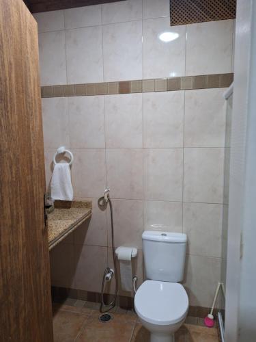 a bathroom with a white toilet and a shower at Casa com ar condicionado in Lauro de Freitas