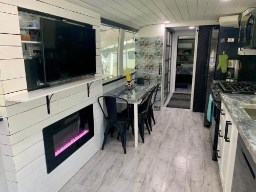 a kitchen with a table and a tv on the wall at Pet friendly tiny home, No extra fees! The Jitney in Clermont