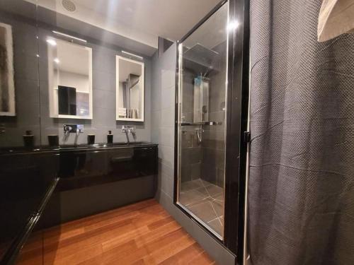 une salle de bain avec une douche en verre et un lavabo dans l'établissement Appartement de 90m² situé dans le Vieux-Lille., à Lille