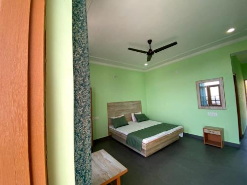 Happy home stay, Dharamshala في دارامشالا: غرفة نوم بسرير ومروحة سقف