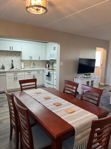 uma cozinha com uma mesa de madeira com cadeiras e uma sala de jantar em Wondrous Waterfront Condo w/ Pool & Washer/Dryer em Fort Walton Beach