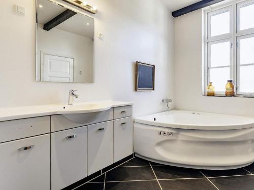 a bathroom with a sink and a tub and a mirror at 20 person holiday home in Svendborg in Svendborg