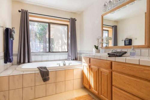 een badkamer met een bad, een wastafel en een spiegel bij Luxury Cabin: Hot Tub, Sauna, Pool and Sleeps 10 in Dorrington