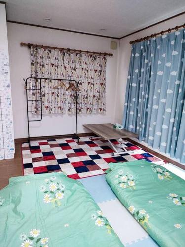 a bedroom with two beds and a checkered floor at Home Stay 北国分 in Ichikawa