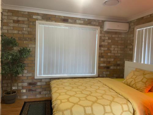 a bedroom with a bed and a large window at Spacious studio unit in Rochedale South
