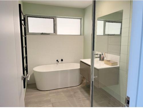 Lovely room with private bathroom في خليج ساندي: حمام مع حوض أبيض ومغسلة