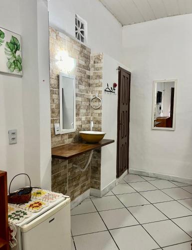 ein Badezimmer mit einem Waschbecken und einer Theke mit einem Waschbecken in der Unterkunft Pousada Cafe e Mar Jeri in Jericoacoara
