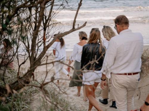 a group of people walking on the beach at Bangalay Luxury Villas in Shoalhaven Heads