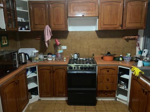 uma cozinha com um fogão preto e armários de madeira em Baquedano em Antofagasta