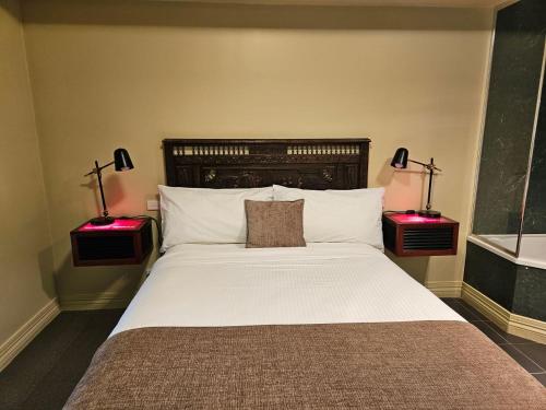 a bedroom with a large bed with two lamps at The Camperdown Mill in Camperdown