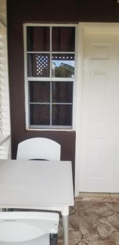 a white table and two chairs in front of a window at Ali's Apartment in Hyde Park