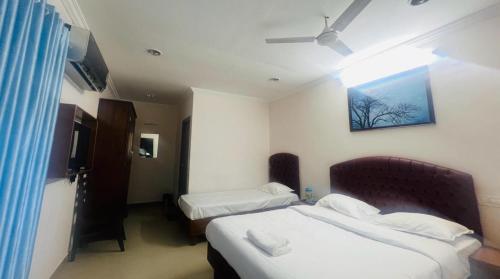 Habitación de hotel con 2 camas y ventana en ROYAL INN en Thiruvananthapuram