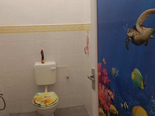 關丹的住宿－AV HOMESTAY，浴室设有卫生间,墙上挂有恐龙