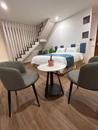 a bedroom with a bed and a table and chairs at Athens Vacation Club House in Magong