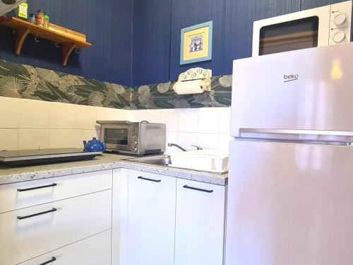 La cuisine est équipée d'un réfrigérateur blanc et d'un four micro-ondes. dans l'établissement Appartement T2 à 50m de la plage à Collioure - FR-1-309-407, à Collioure