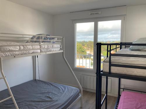 une chambre avec deux lits superposés et une fenêtre dans l'établissement Appartement moderne 2 chambres, vue mer, WiFi, Saint-Jean-de-Monts - FR-1-323-230, à Saint-Jean-de-Monts