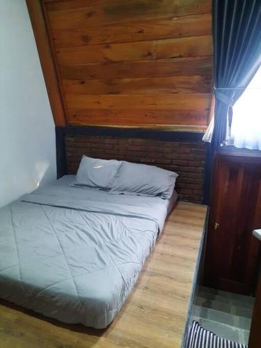 a bed in a room with a wooden ceiling at Villa As-salam, Kadungora, Garut in Garut