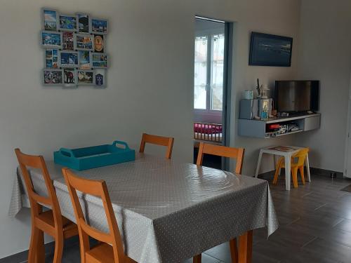 une salle à manger avec une table, des chaises et une télévision dans l'établissement Maison plain-pied à Saint-Hilaire-de-Riez, près de la mer, idéale pour 6 pers., jardin et terrasse - FR-1-323-470, à Saint-Hilaire-de-Riez