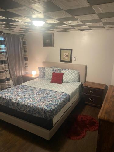 Un dormitorio con una cama con una almohada roja. en Havre de paix, en Laval