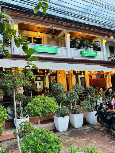 a building with a bunch of potted plants in front of it at Mano boutique sun shine in Luang Prabang