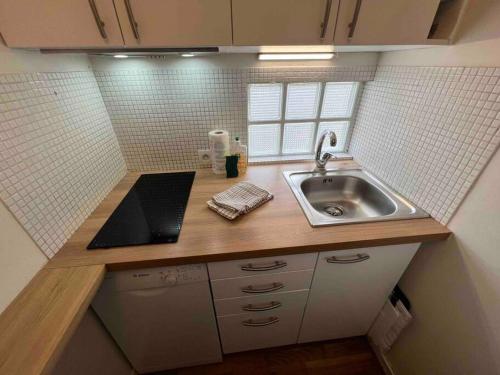 une petite cuisine avec un évier et un comptoir dans l'établissement Tour Eiffel - Studio vue imprenable au-dessus des toits, balcon, à Paris