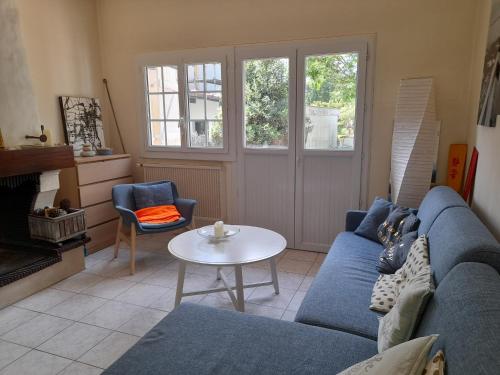 un salon avec un canapé bleu et une table dans l'établissement Maison au Calme avec Jardin et Terrasse, Proche Plage et Pistes Cyclables, Bien Équipée - FR-1-319-517, à Arcachon
