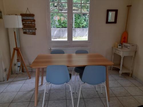une table à manger avec quatre chaises et une fenêtre dans l'établissement Maison au Calme avec Jardin et Terrasse, Proche Plage et Pistes Cyclables, Bien Équipée - FR-1-319-517, à Arcachon